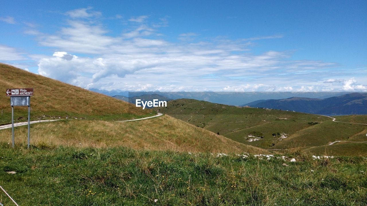 SCENIC VIEW OF FIELD AND MOUNTAINS AGAINST SKY