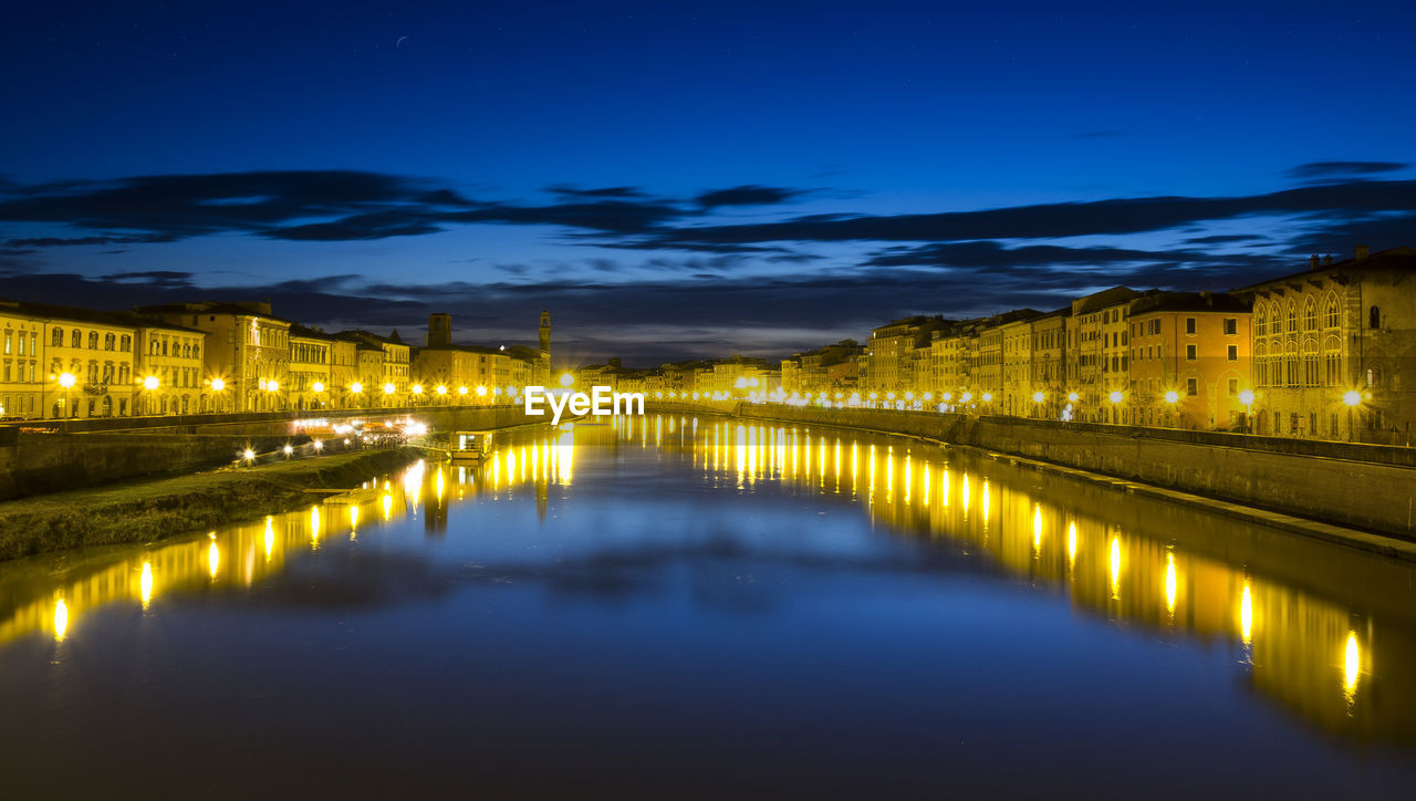 Illuminated bridge over river against sky in city at night