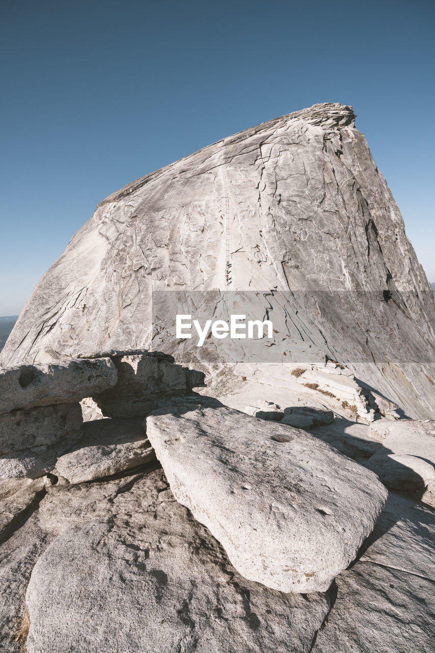 Tourists hiking up cable secured section of half dome in yosemite np