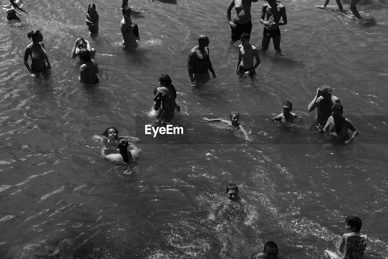 HIGH ANGLE VIEW OF PEOPLE SWIMMING AT WATER