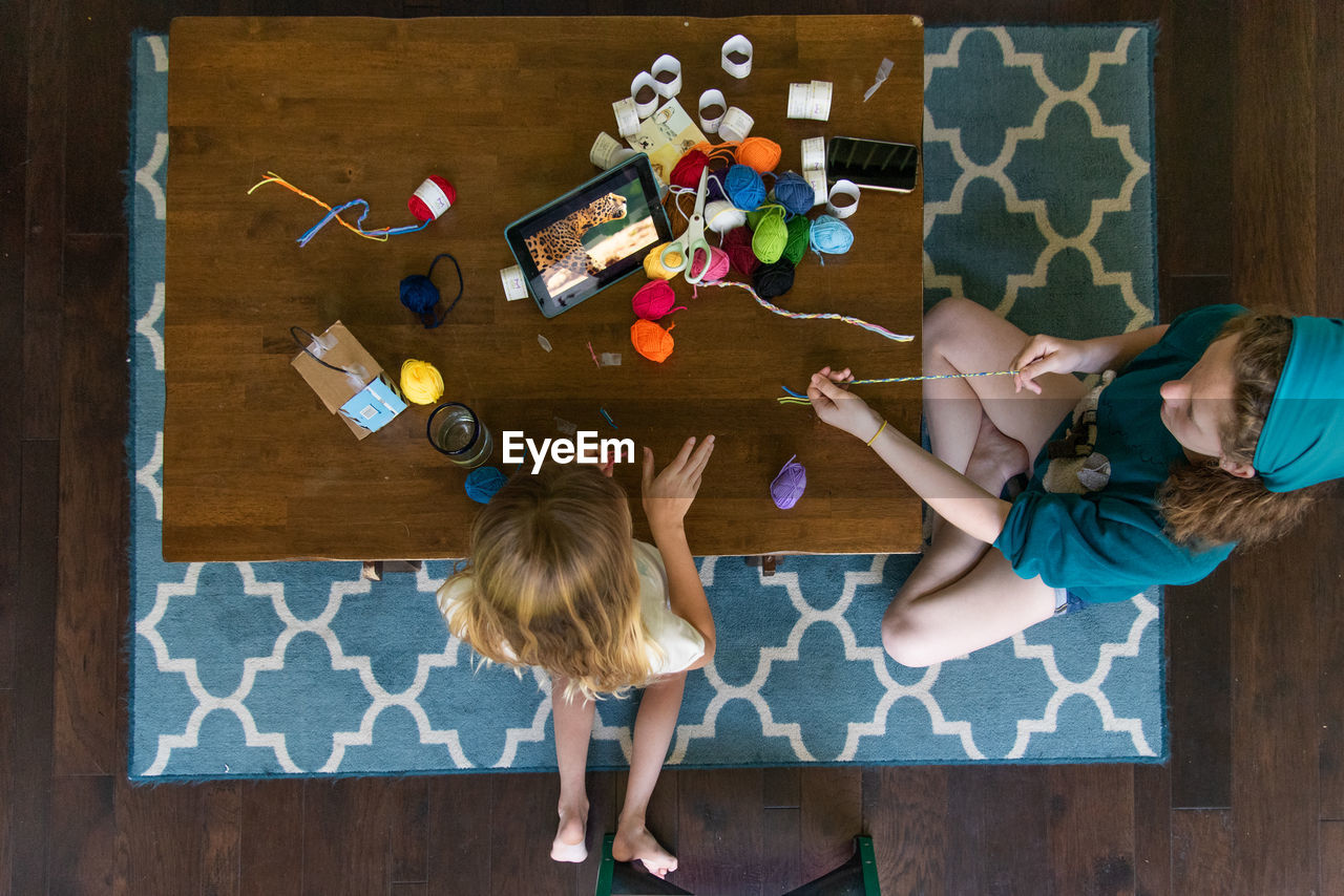 High angle view of girls sitting on table