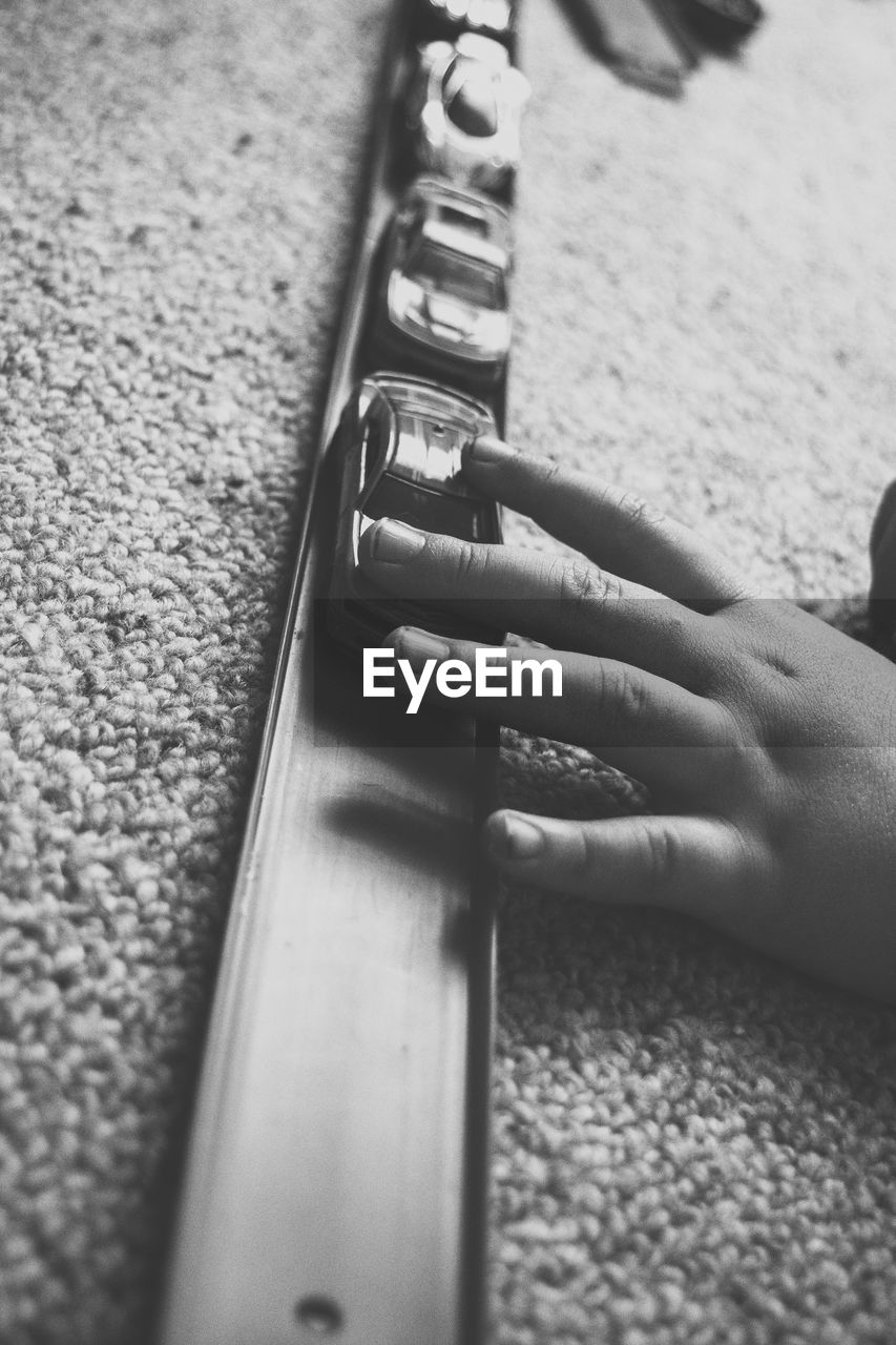 HIGH ANGLE VIEW OF WOMAN WITH HANDS ON RUG