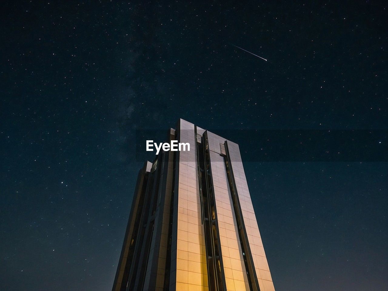 low angle view of modern building against sky at night