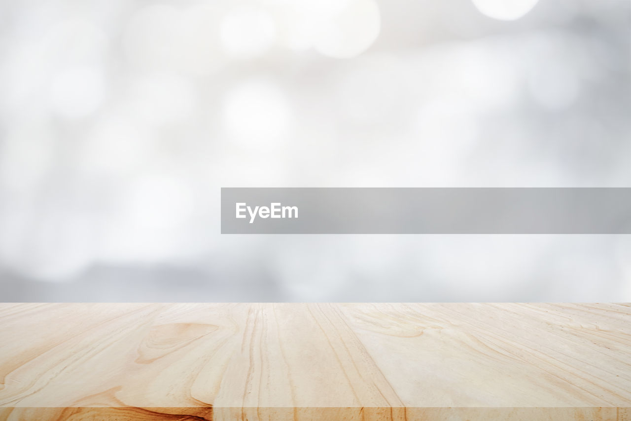 Empty wooden table for present product on white bokeh blur backg