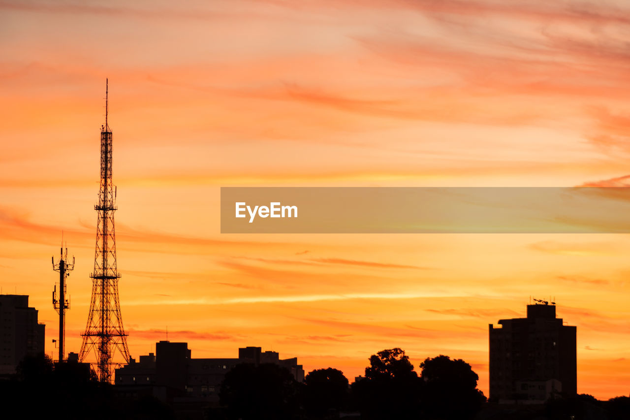 SILHOUETTE BUILDING AGAINST ORANGE SKY