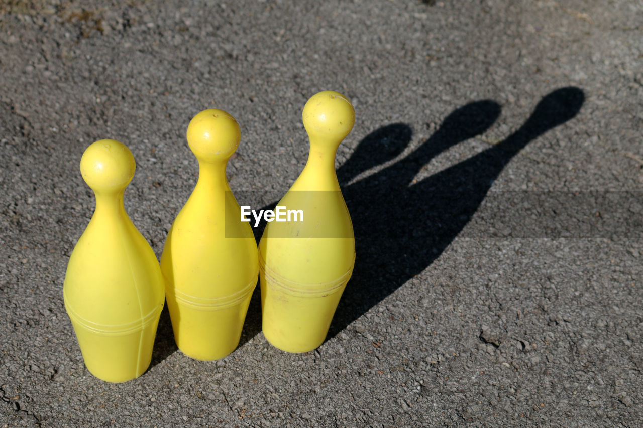 High angle view of yellow bowling pins on road