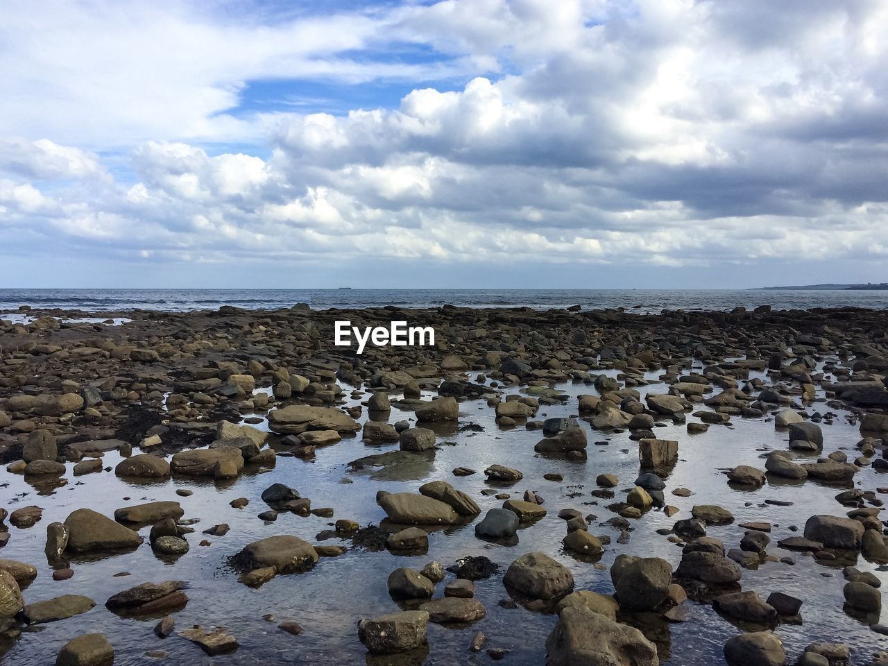 Rocks on beach against sky