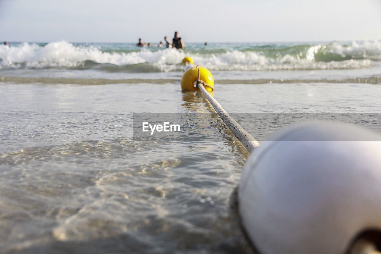 Close-up of buoys floating with rope in sea