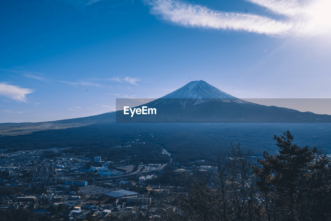 mountain, volcano, sky, landscape, environment, travel destinations, beauty in nature, scenics - nature, nature, horizon, snow, cloud, mountain peak, land, travel, no people, stratovolcano, volcanic landscape, dawn, cold temperature, winter, city, snowcapped mountain, blue, outdoors, culture, tourism, mountain range, architecture, tree, morning, tranquility, plant, tranquil scene, geology, sunrise