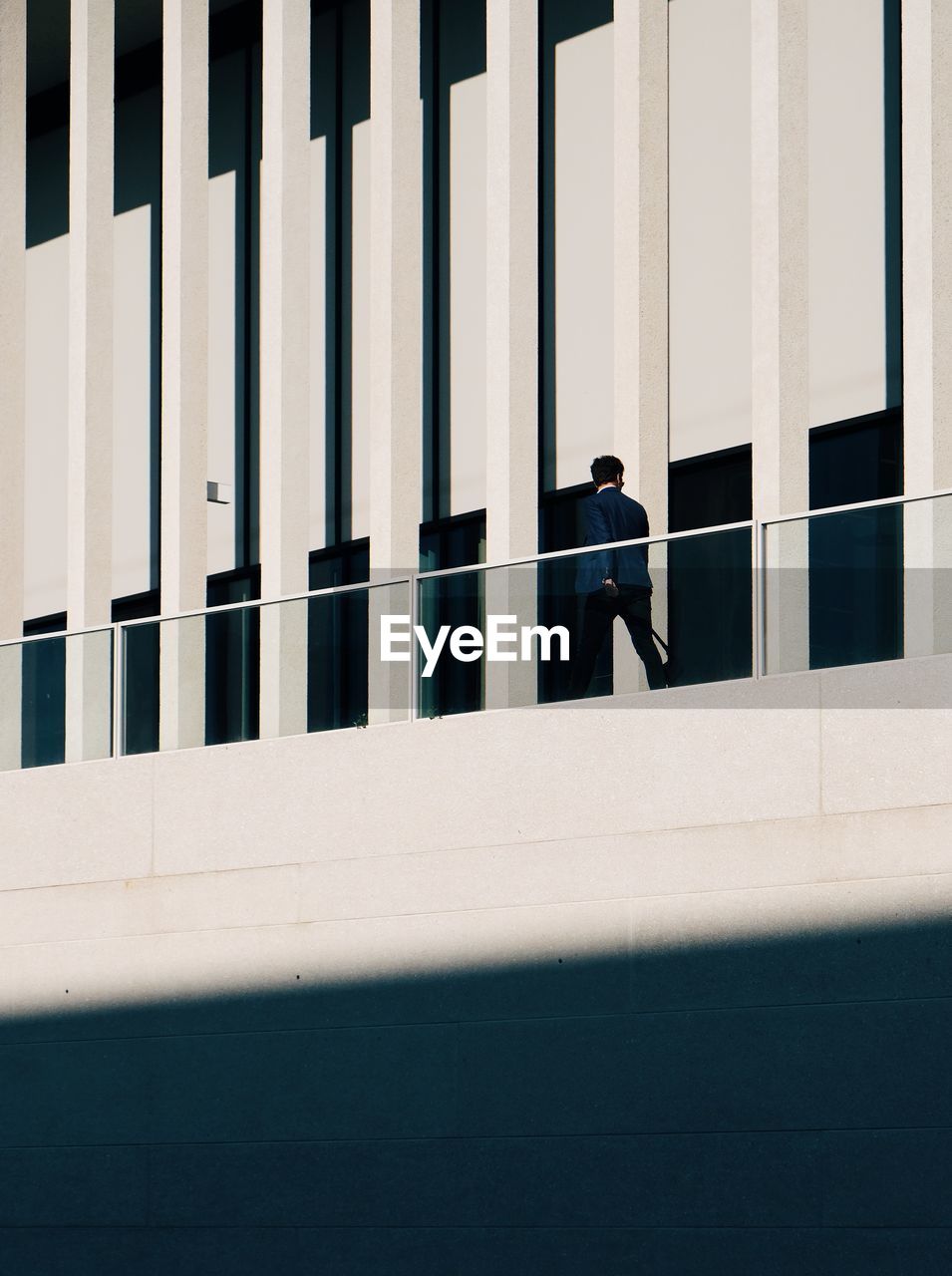 Low angle view of man walking on building balcony