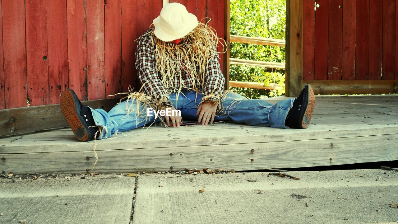 Full length of man imitating scarecrow at farm