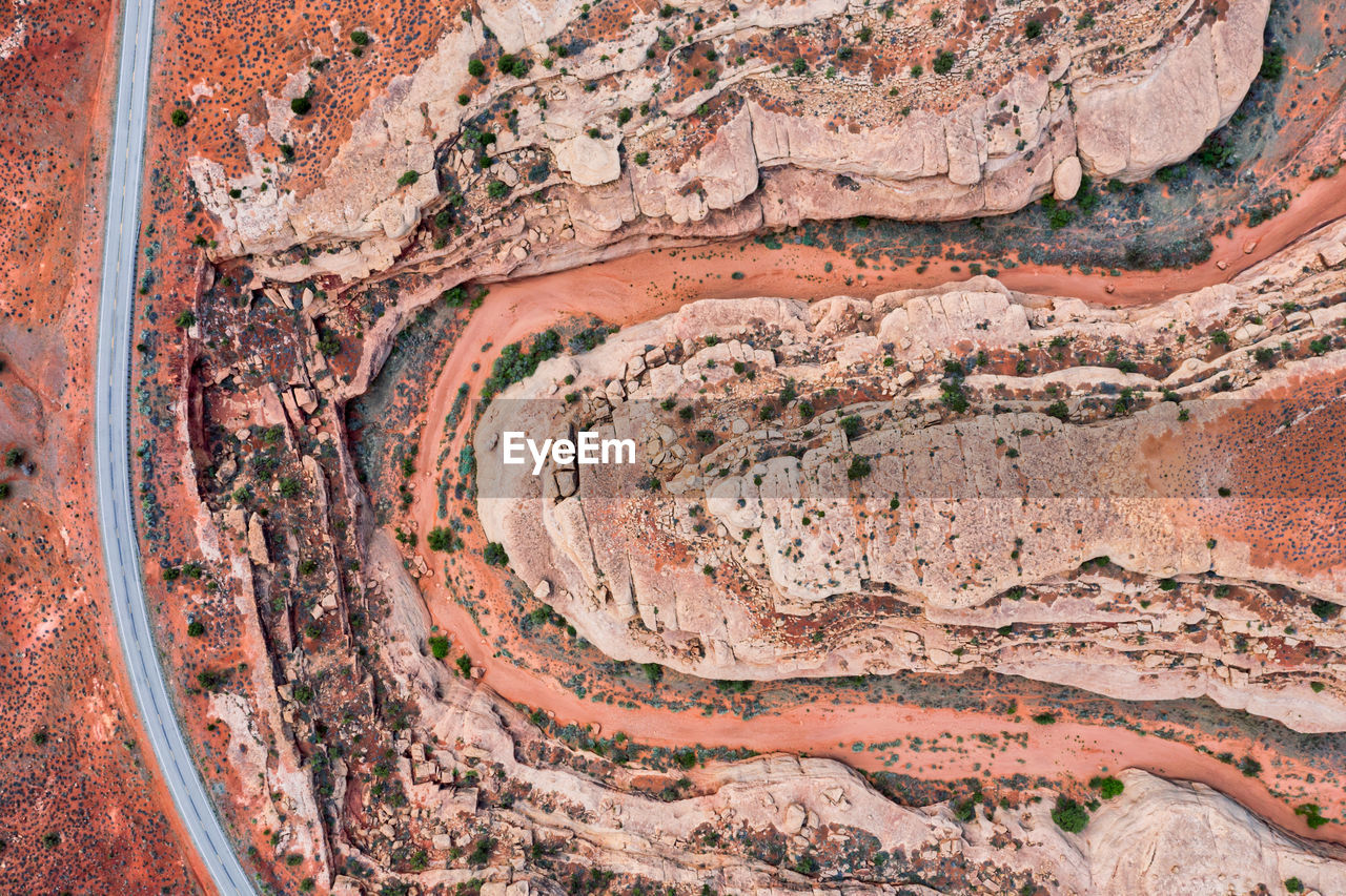 Top down drone photo of highway in utah through red canyon and empty riverbed