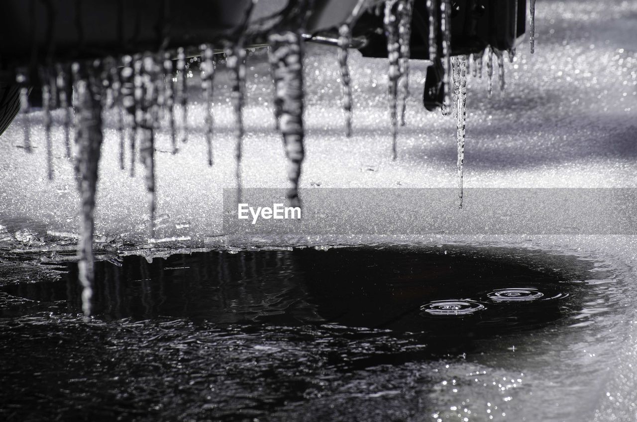 Close-up of icicles on pier over frozen lake