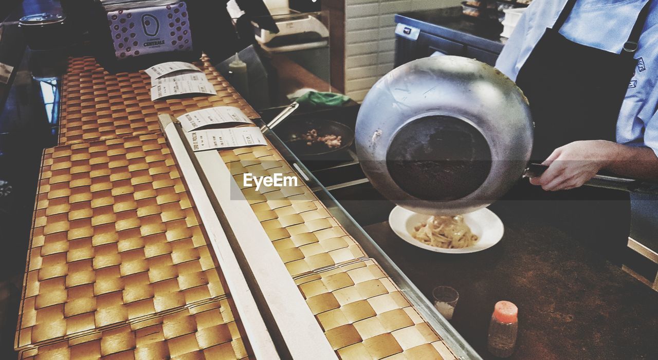 HIGH ANGLE VIEW OF MAN PREPARING FOOD