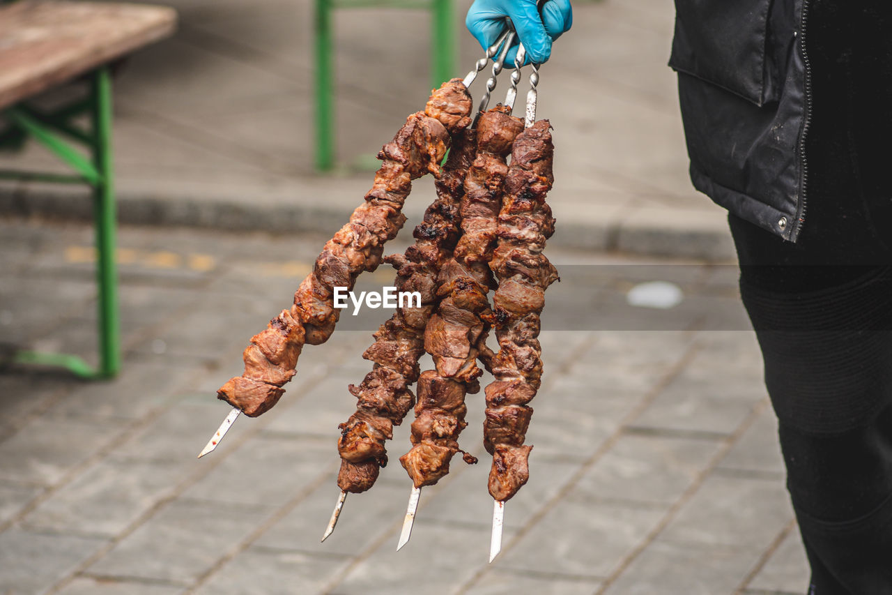 Pork meat skewer, grilled or roasted in a barbecue on an open fire and flames, shashlik or shashlyk