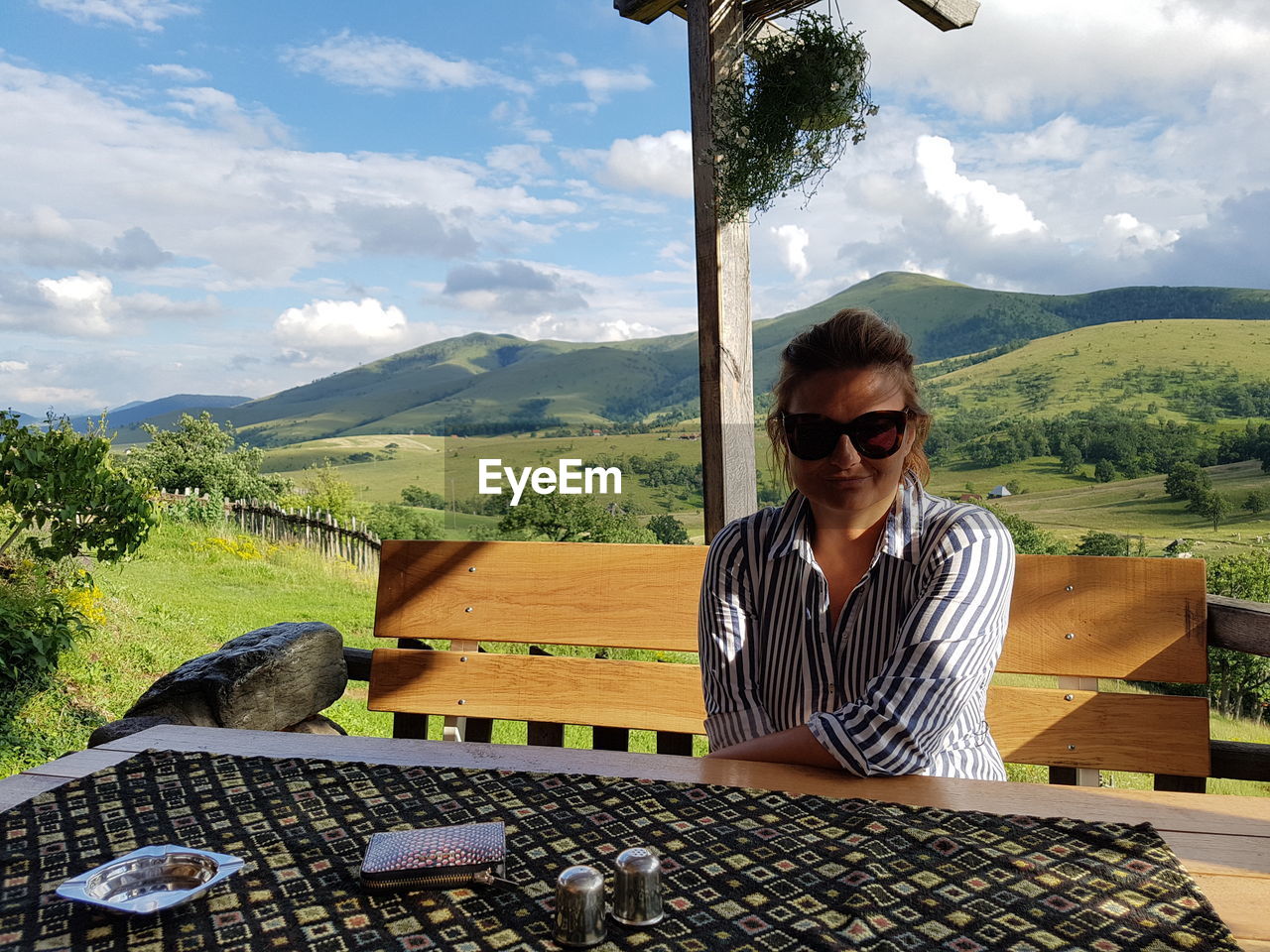 Woman sitting on table against landscape