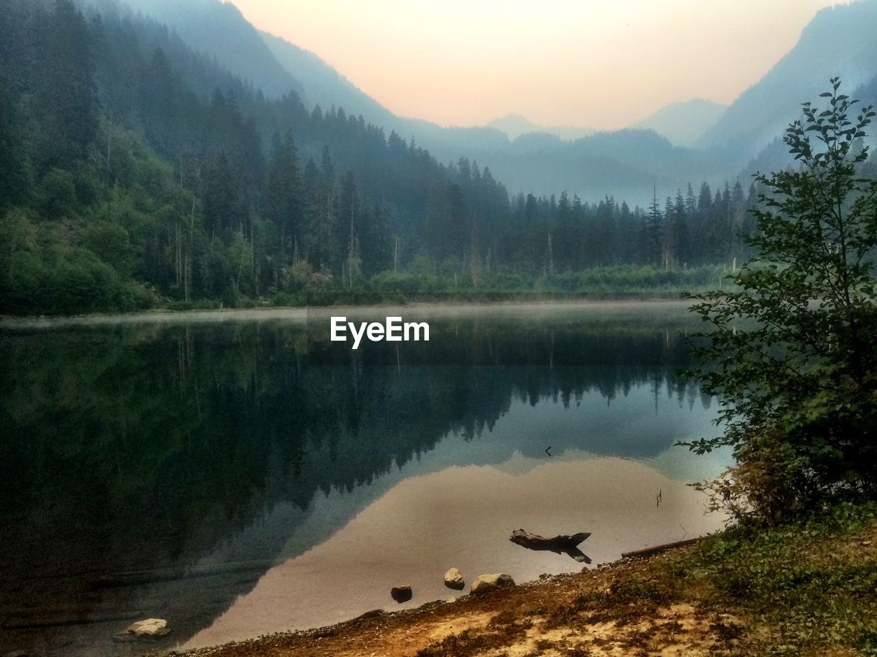 Scenic view of lake with mountains reflection during sunrise