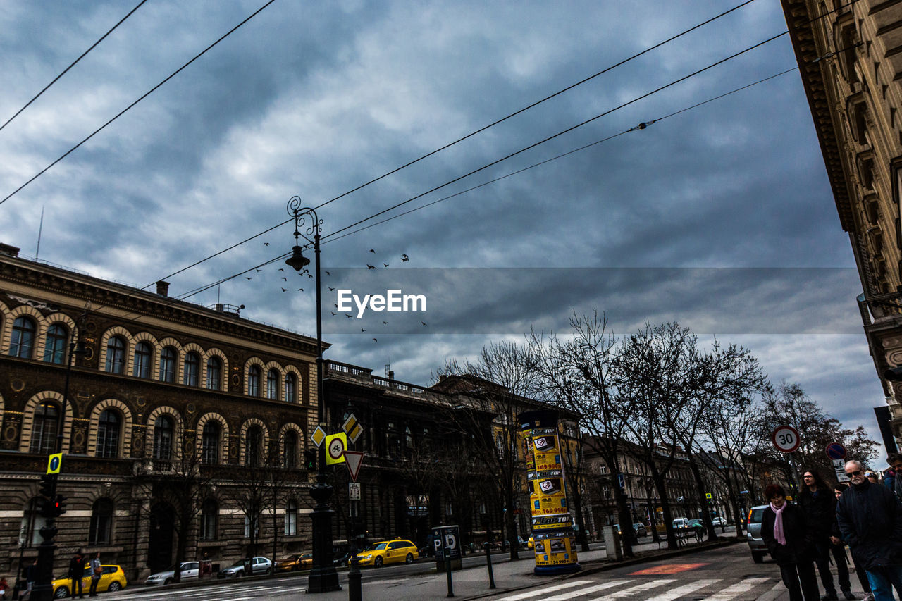 VIEW OF CITY STREET AGAINST CLOUDY SKY