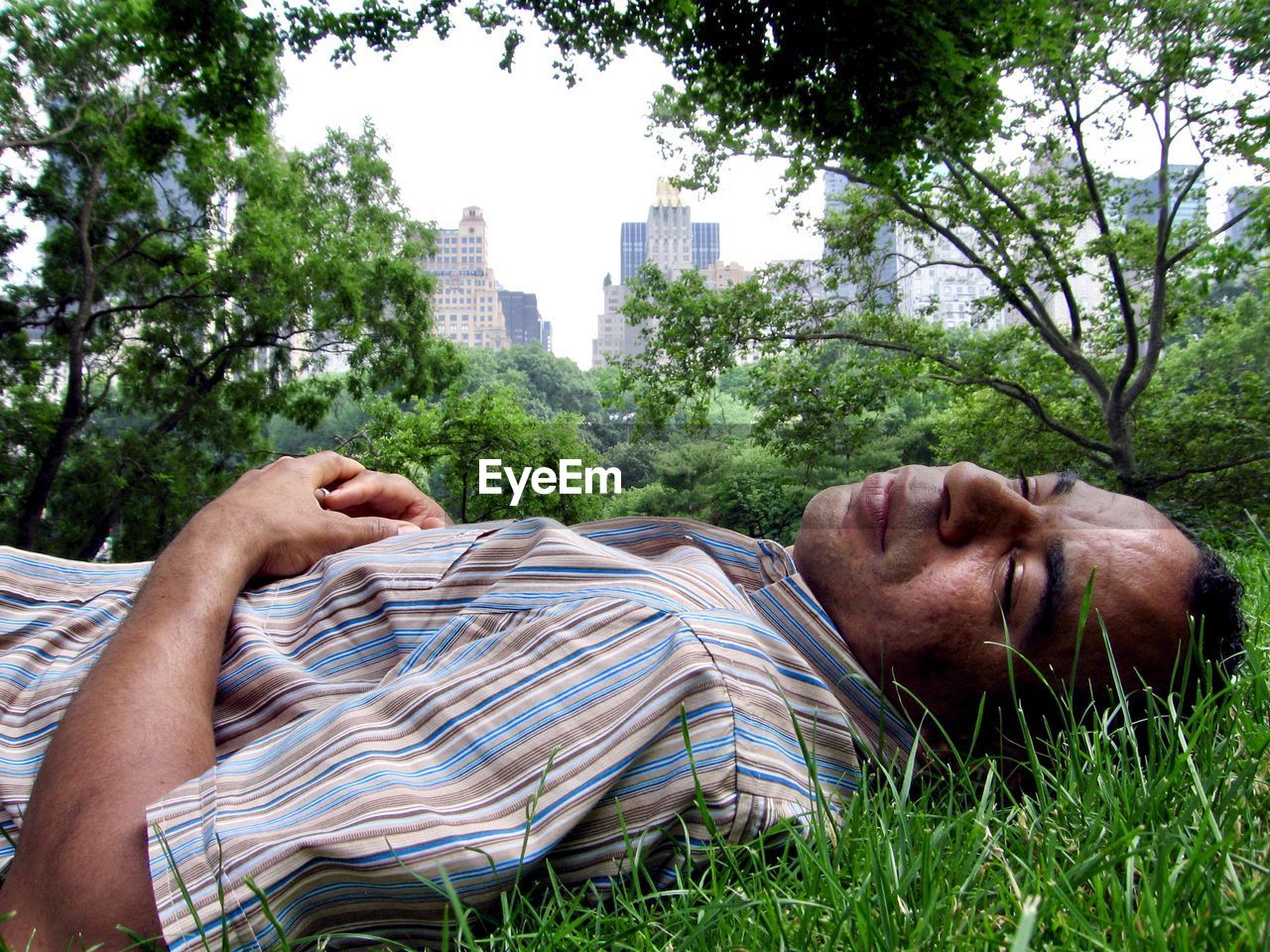 Man sleeping on grass in city