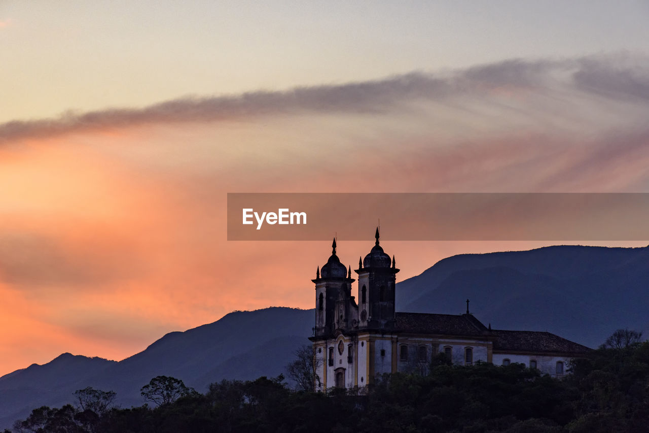 Ancient colonial style church on top of the hill at sunzet