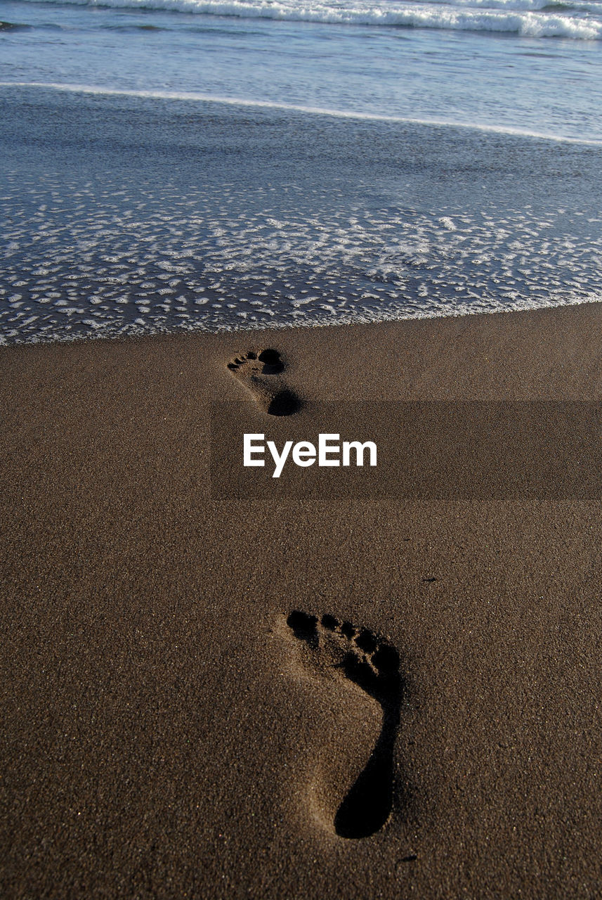 Footprints on beach during sunset on summer beach