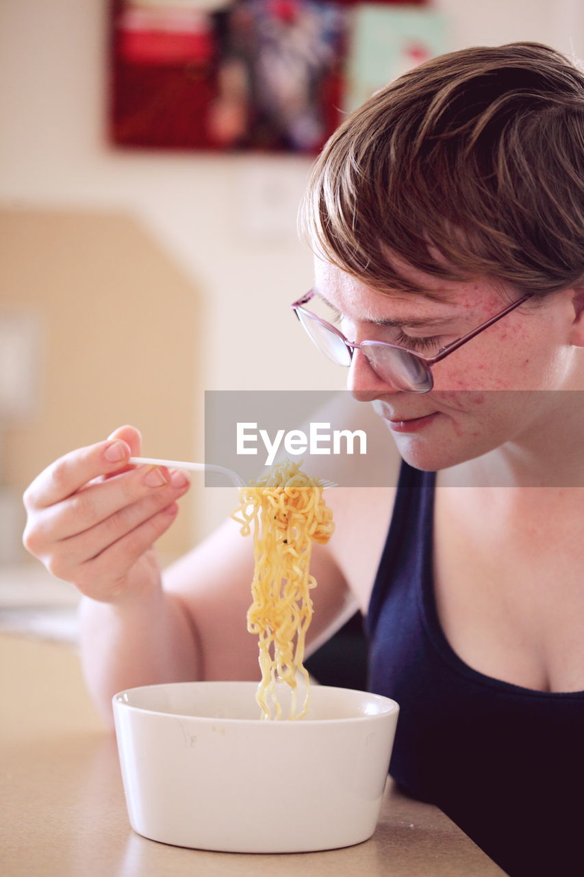 Close-up of woman eating ramen at home