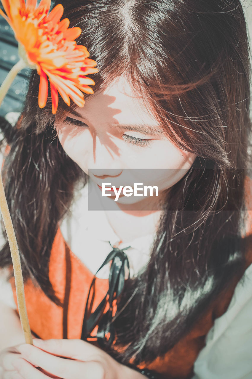 Close-up of beautiful young woman holding flower