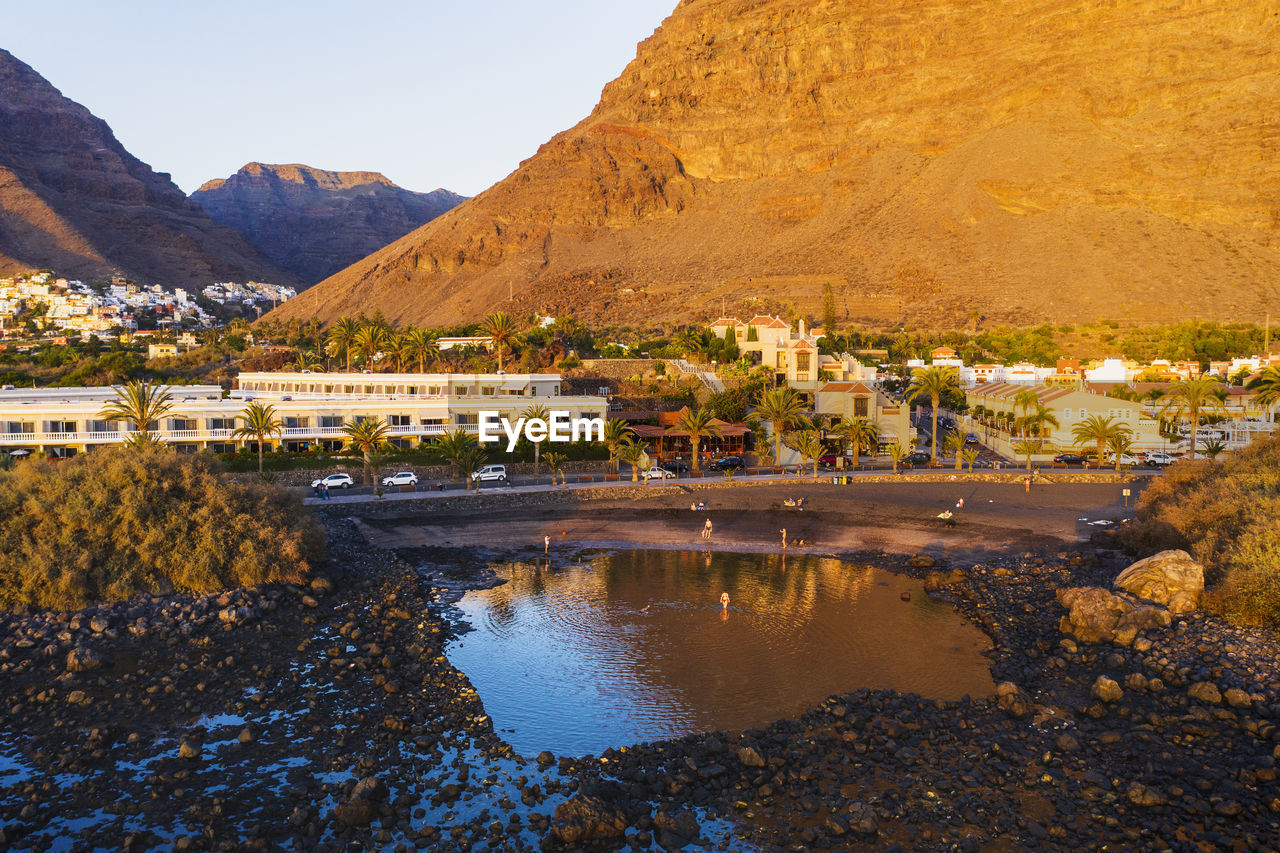 Spain, valle gran rey, drone view of town at edge of la gomera island at dusk