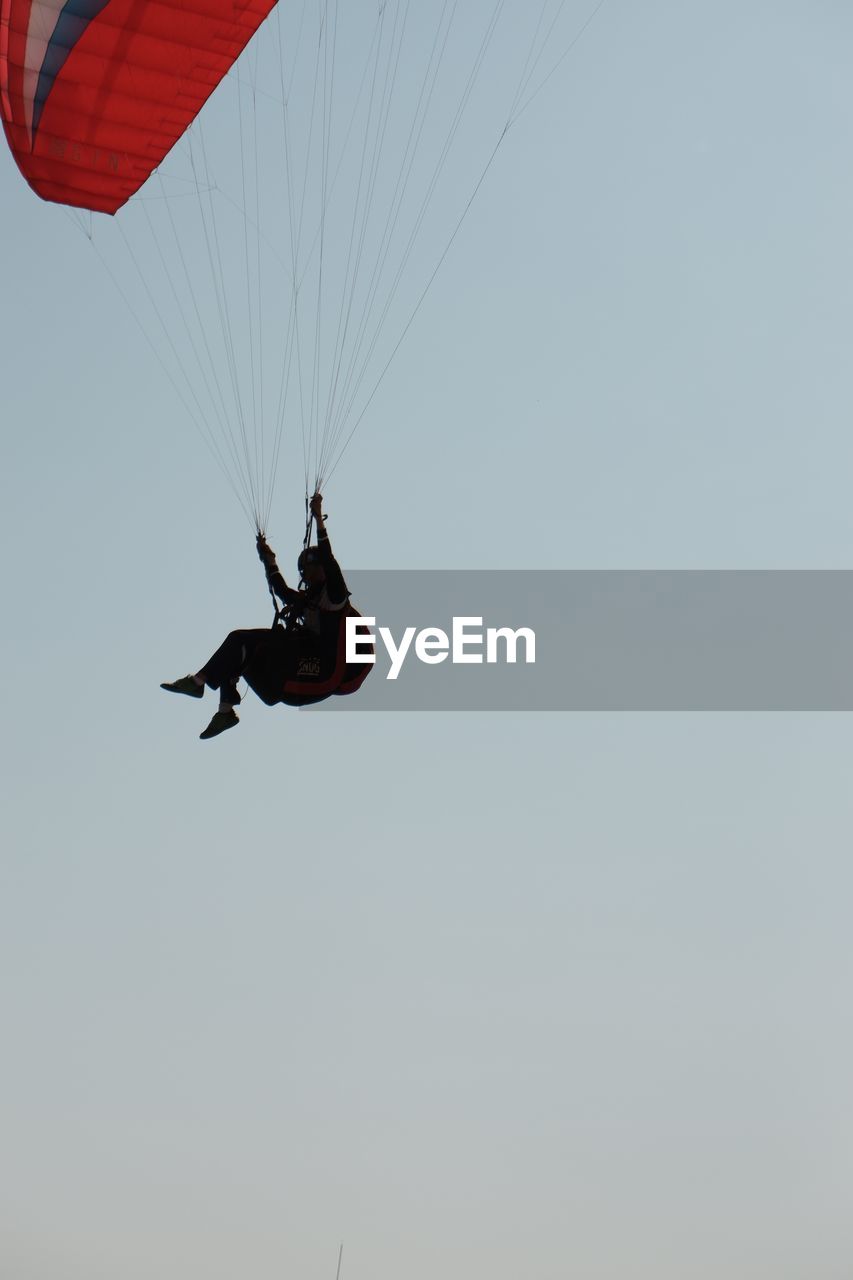 LOW ANGLE VIEW OF PERSON PARAGLIDING