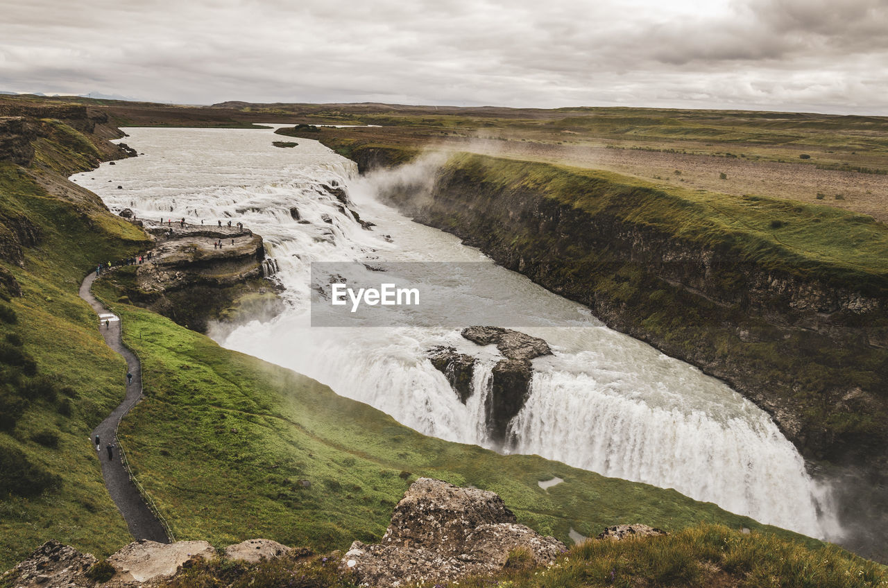 Scenic view of waterfall against sky