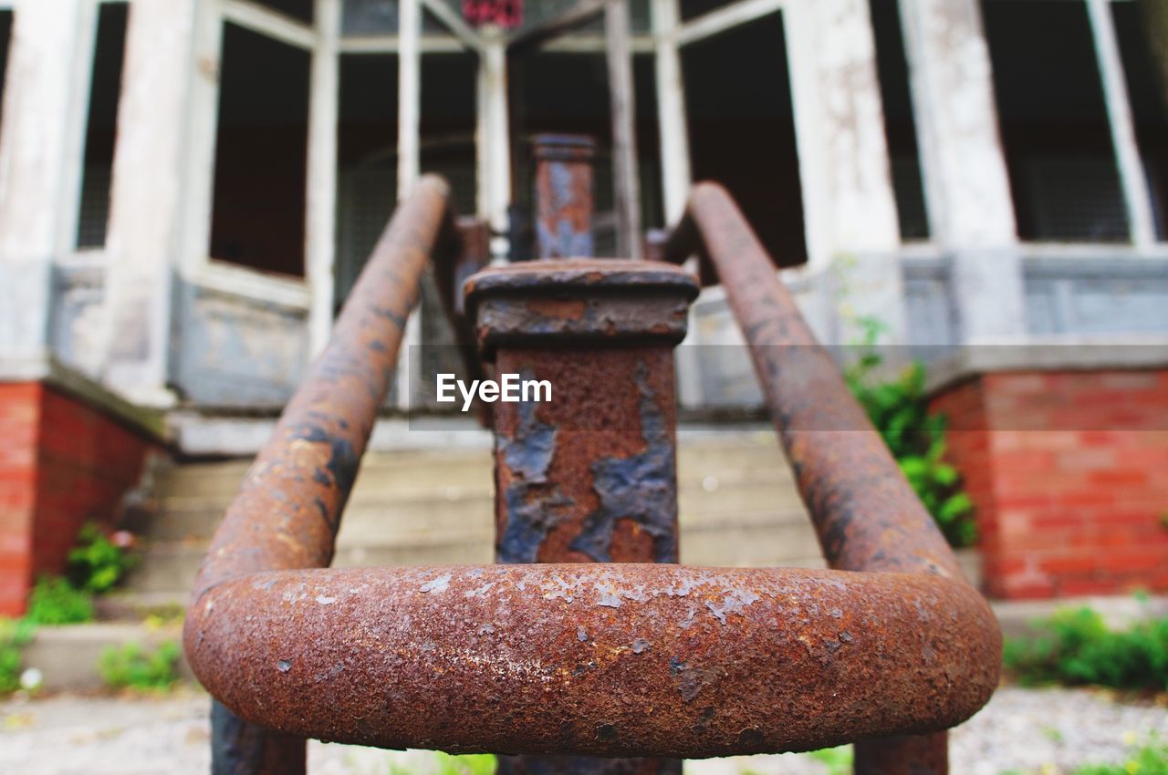 Rusty railing against abandoned house