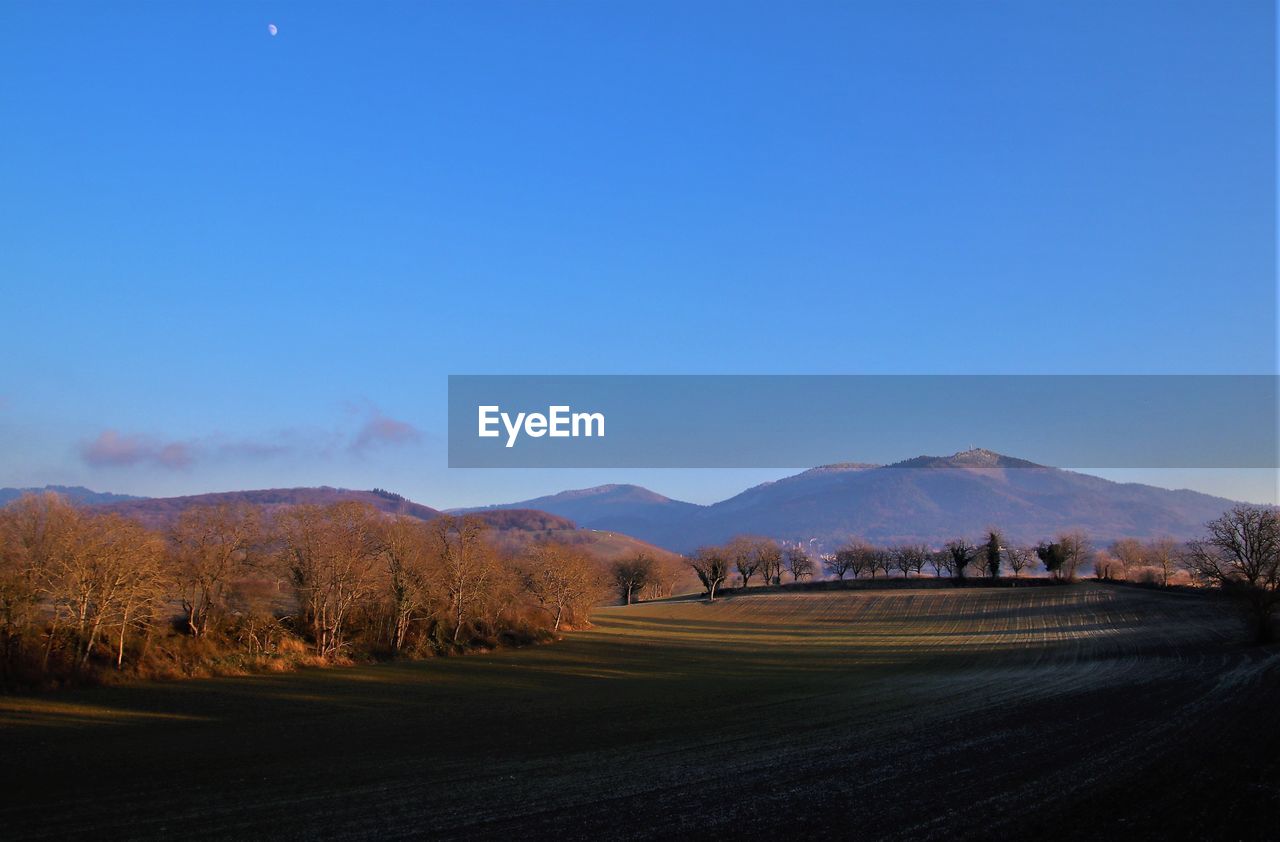 sky, mountain, landscape, scenics - nature, environment, horizon, morning, nature, beauty in nature, dawn, no people, land, tranquility, tranquil scene, plant, tree, blue, mountain range, road, clear sky, outdoors, sunrise, non-urban scene, transportation, moon, cloud