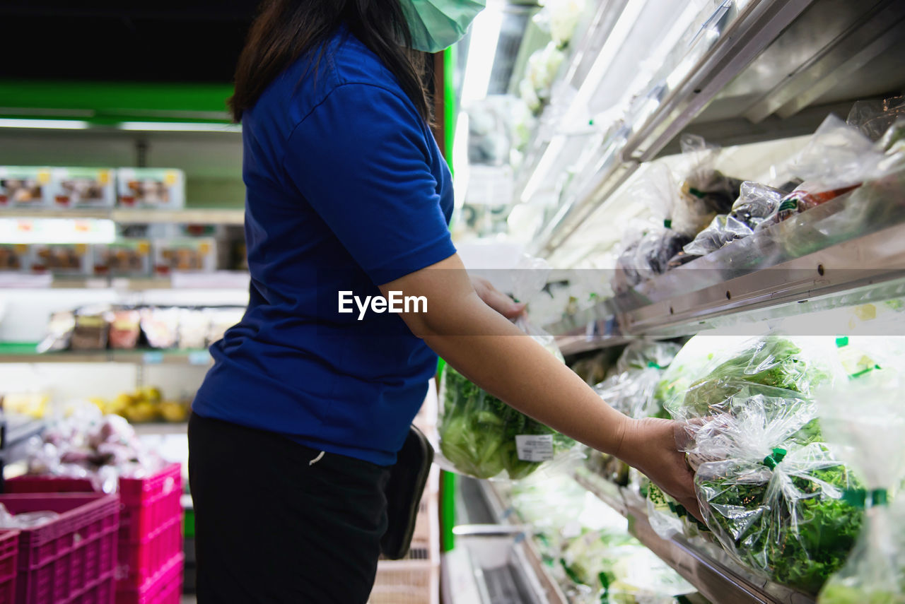 Midsection of woman standing at market stall