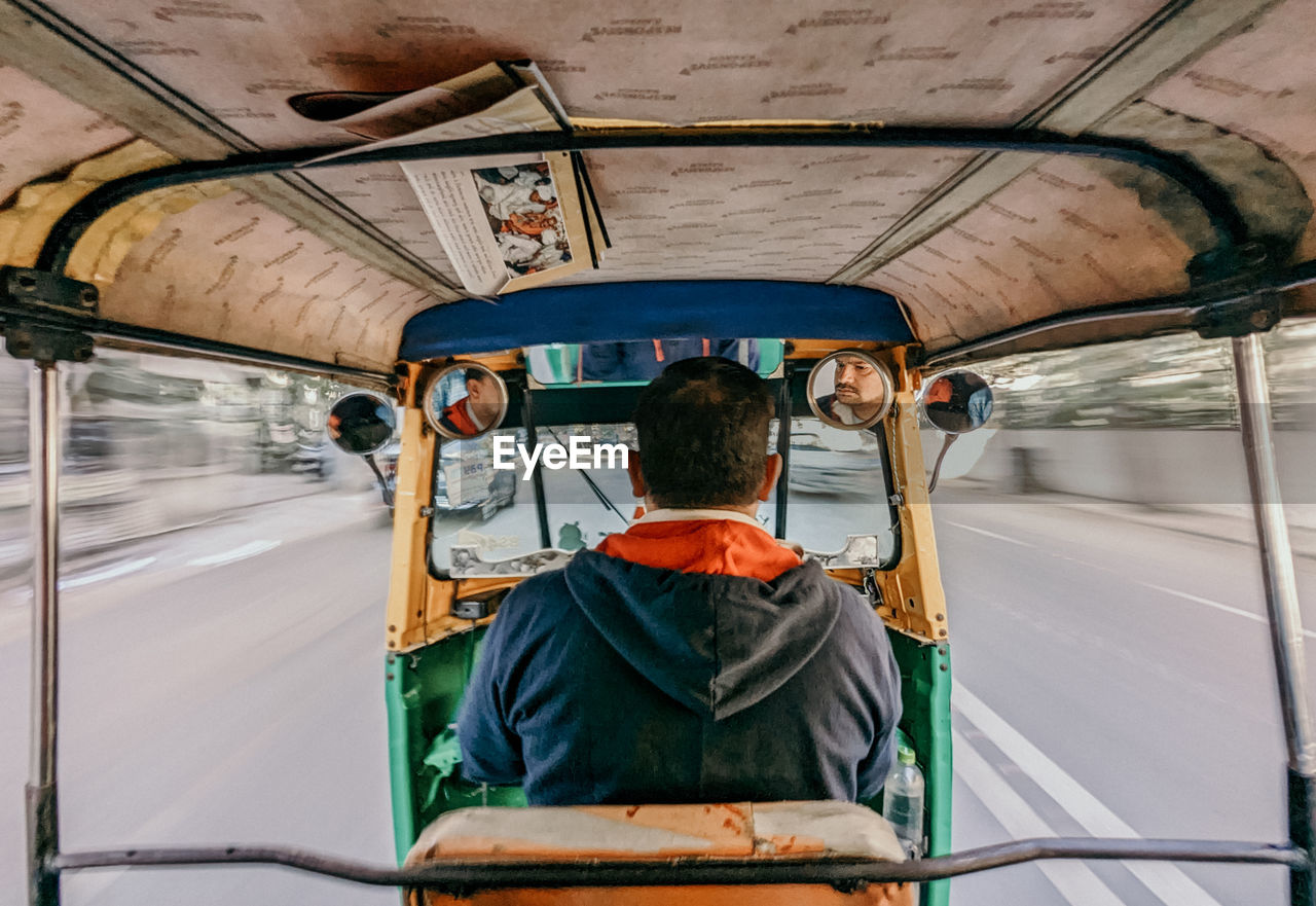 Rear view of man riding autorickshaw 