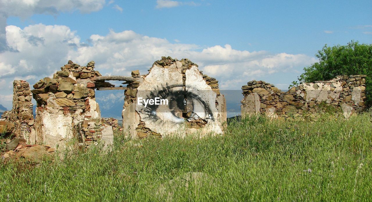 OLD BUILT STRUCTURE AGAINST CLOUDY SKY