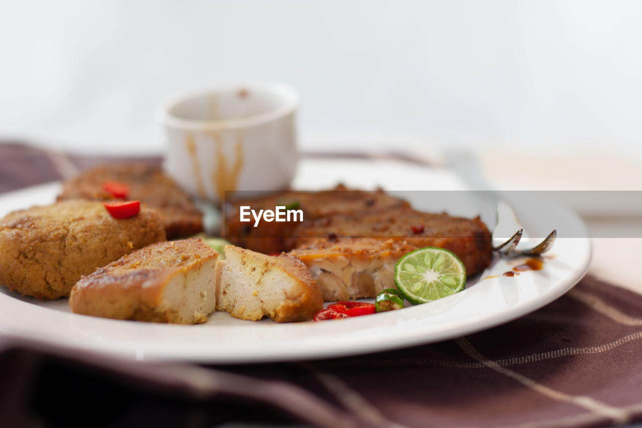 Low angle view of tempe tahu bacem served in plate, indonesian traditional sweet tempeh and tofu