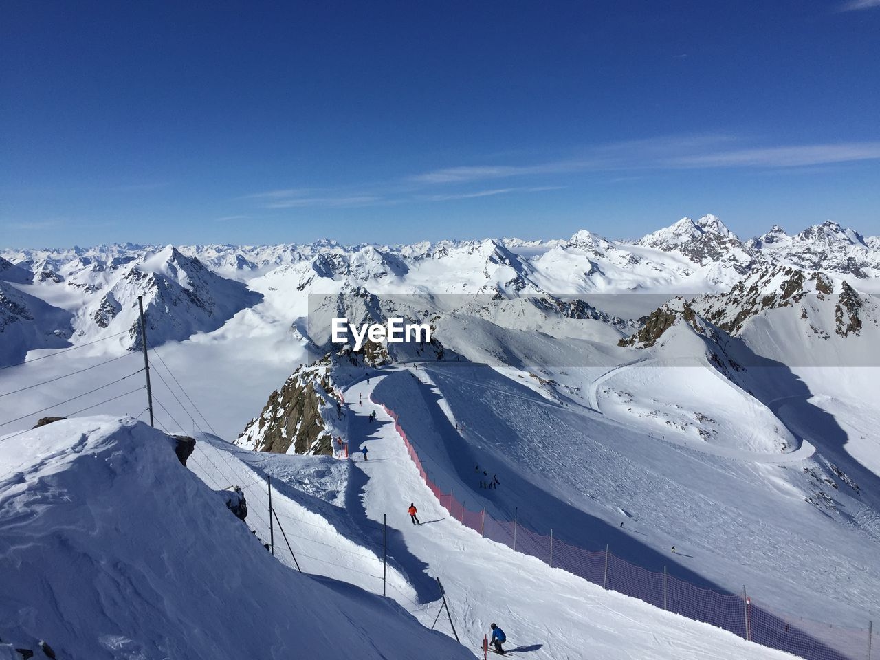 PANORAMIC VIEW OF SNOWCAPPED MOUNTAINS AGAINST BLUE SKY