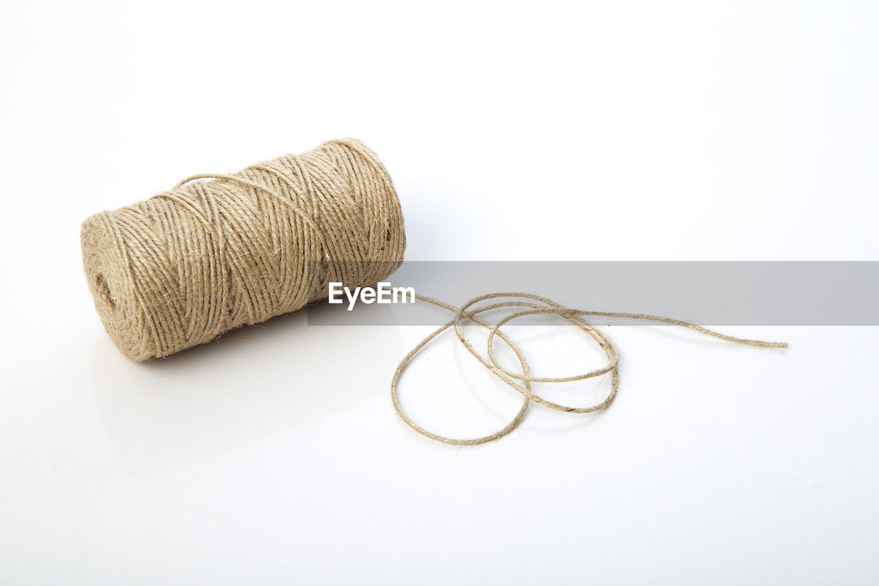 Close-up of wool spool over white background