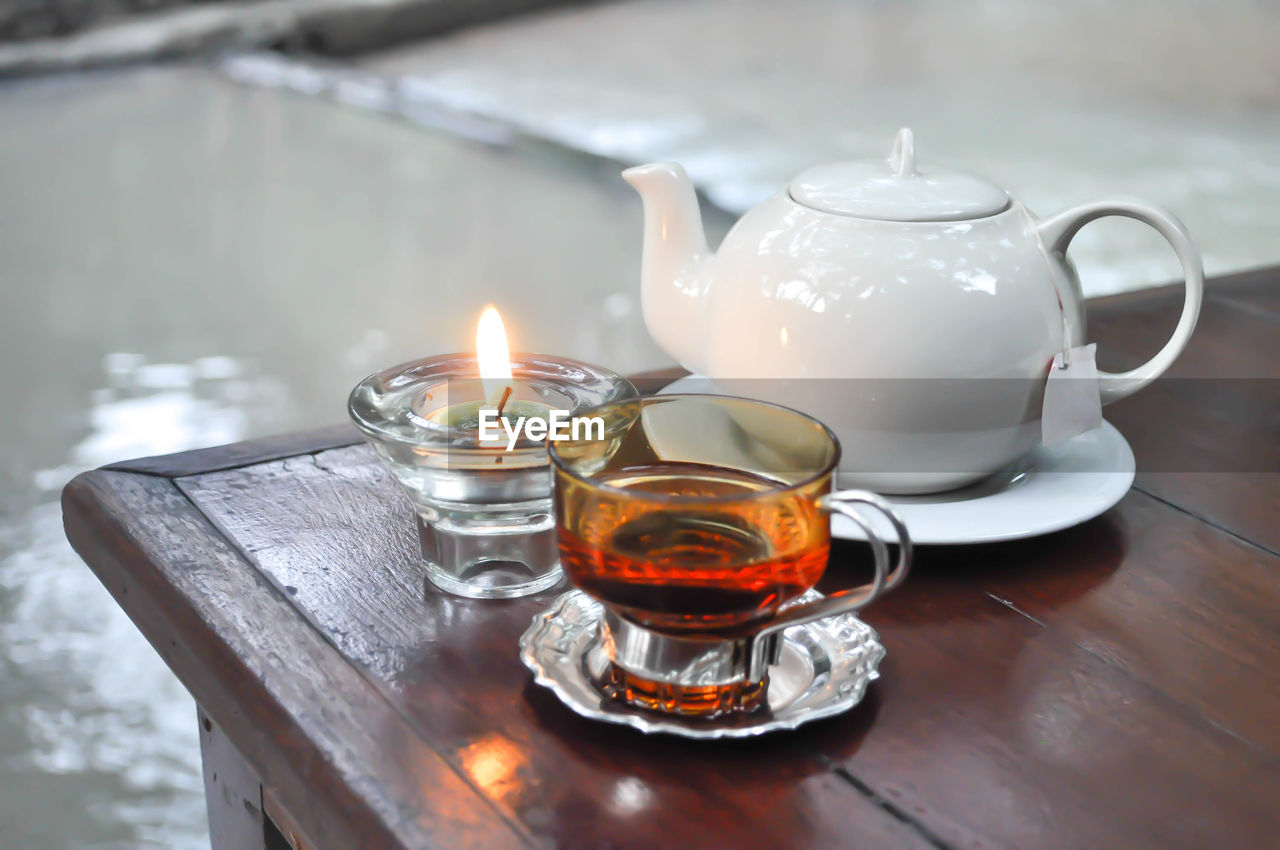 Close-up of candle and herbal tea on table