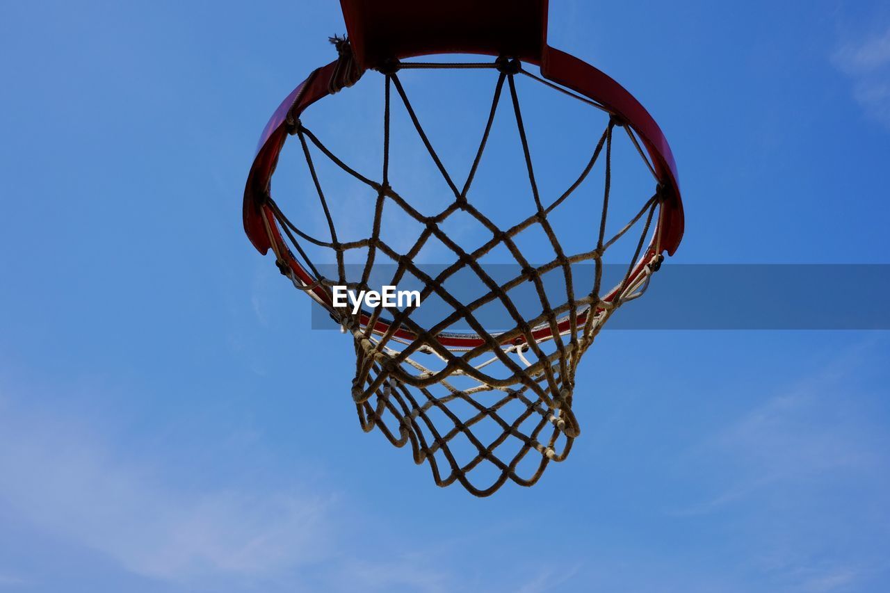 LOW ANGLE VIEW OF BASKETBALL HOOP AGAINST BLUE SKY