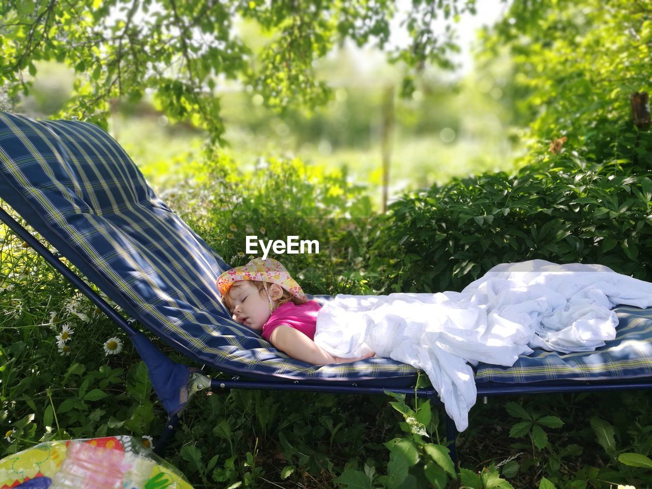 Cute baby girl sleeping on lounge chair in back yard