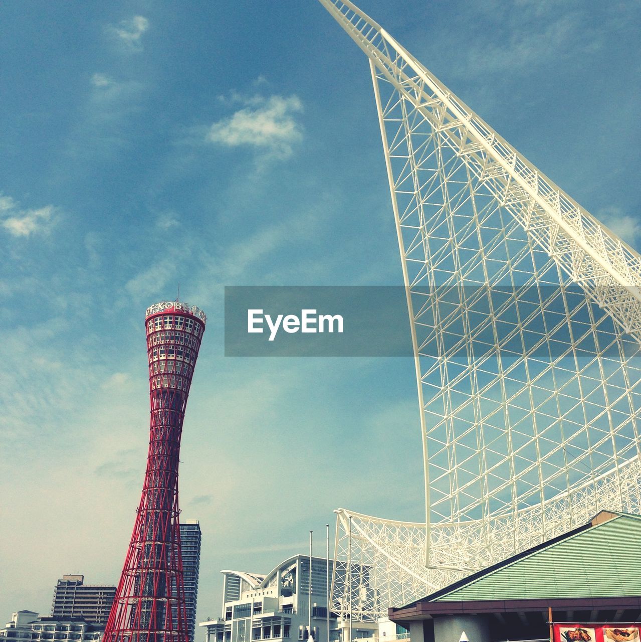 Low angle view of kobe port tower and metal structure against sky