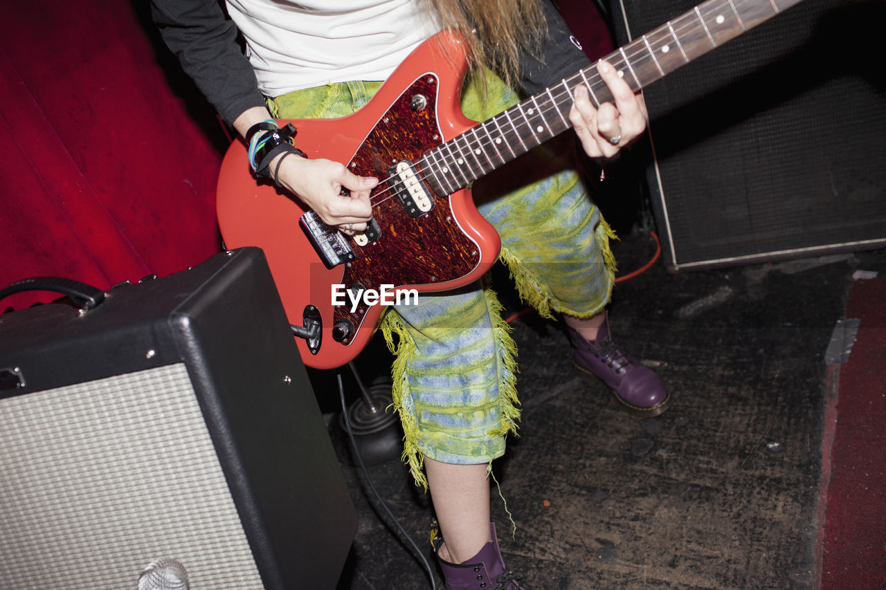 Young woman playing an electric guitar