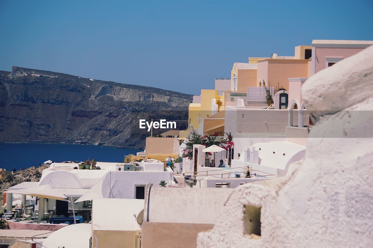 Buildings in city against clear blue sky