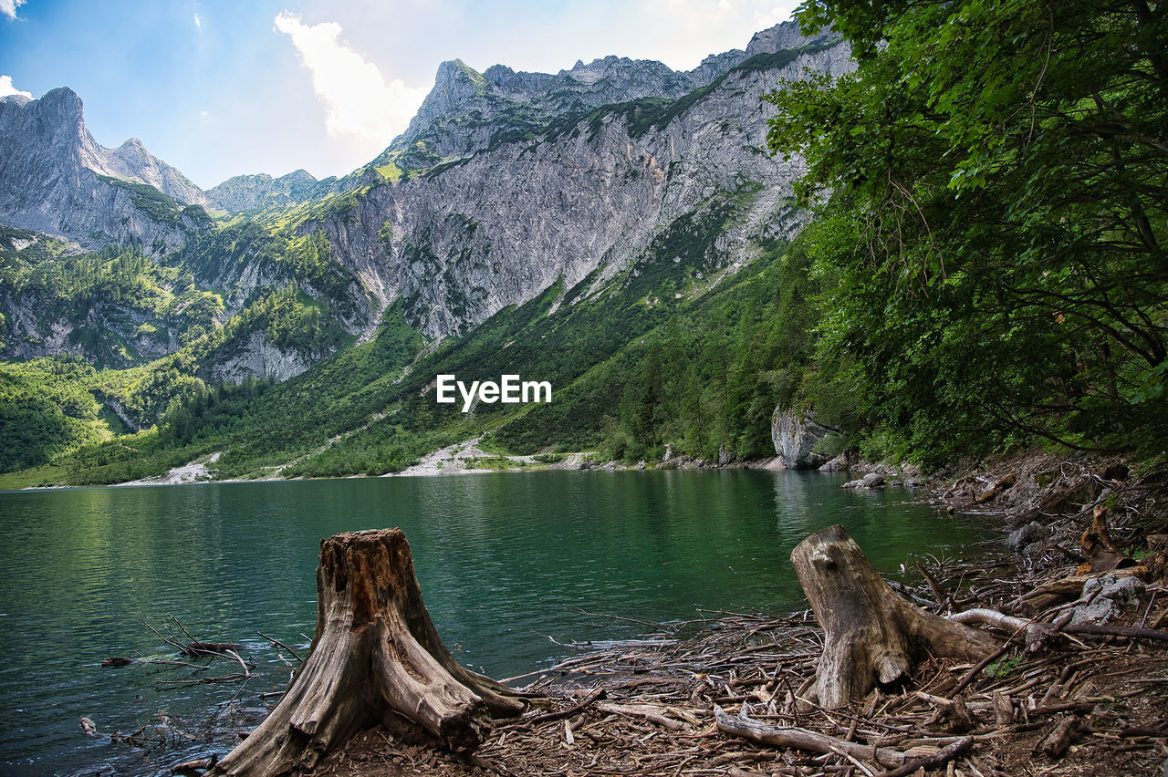 Scenic view of lake by mountain against sky