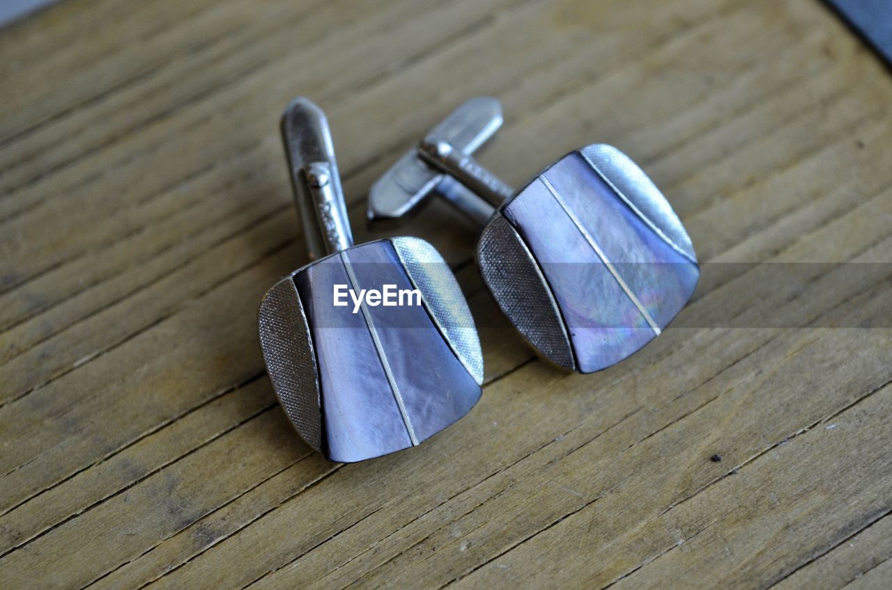 High angle view of cufflinks on wooden table