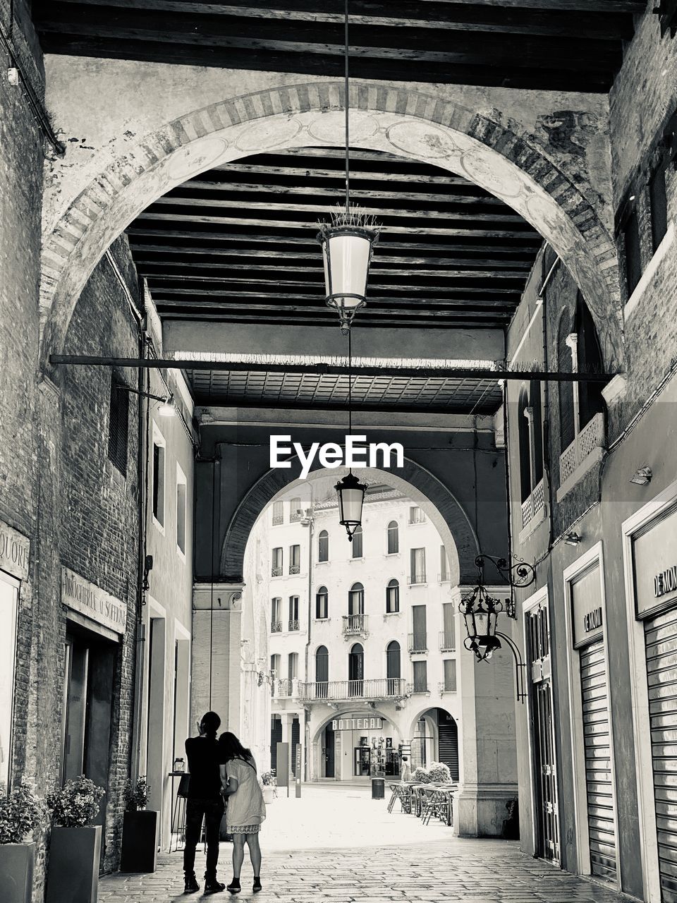 Rear view of people walking on street amidst buildings