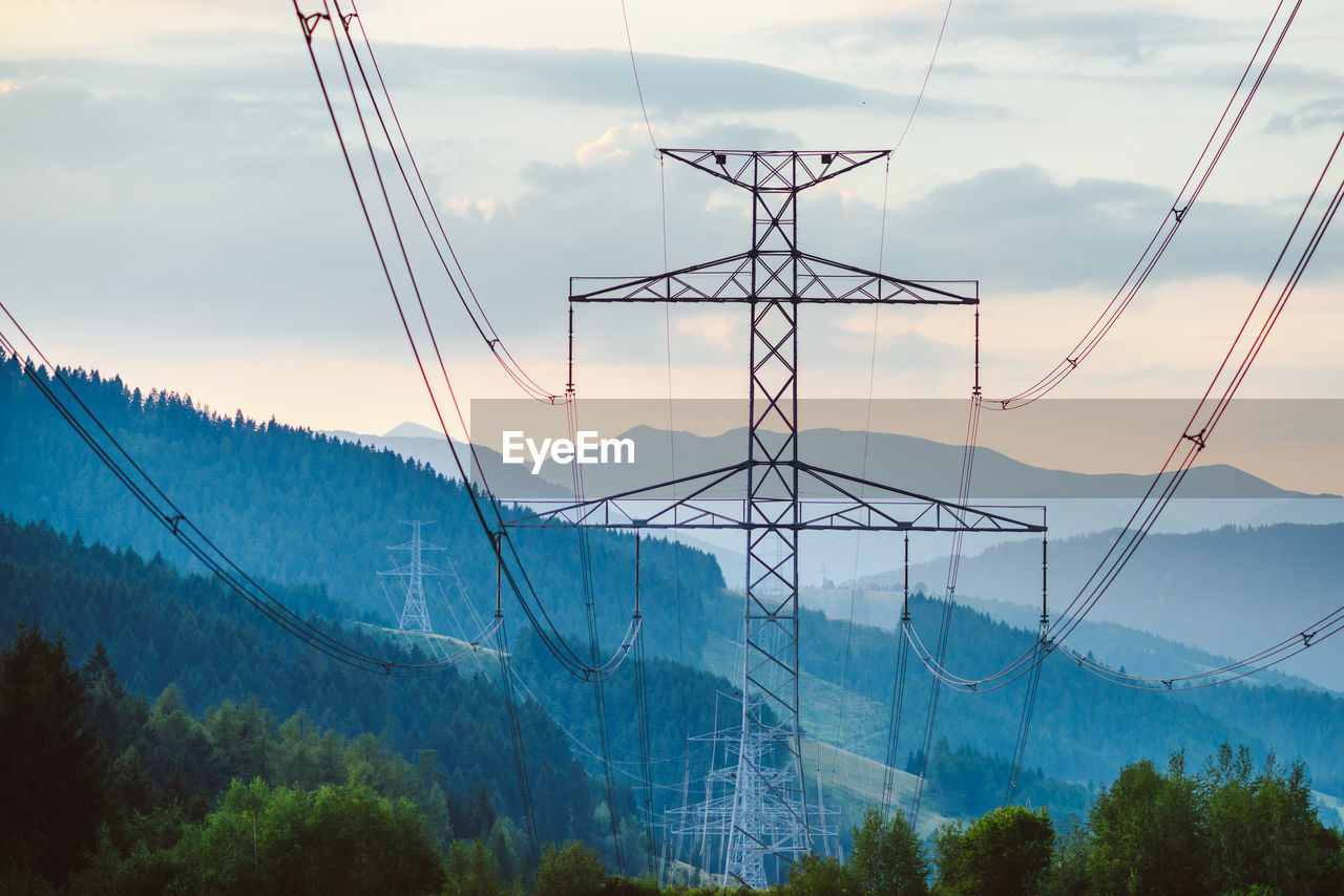 Electricity pylon and mountains against sky