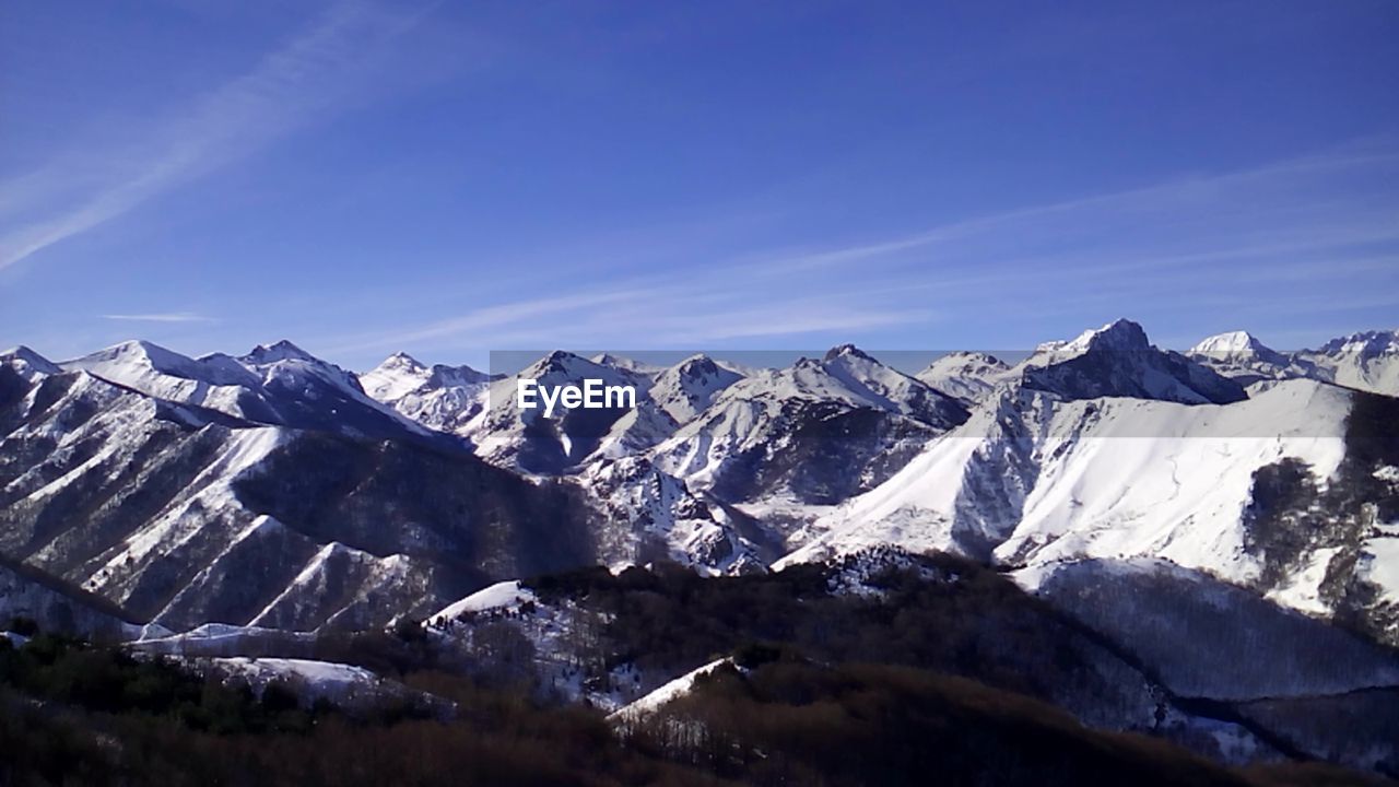 Scenic view of snow covered mountains against sky