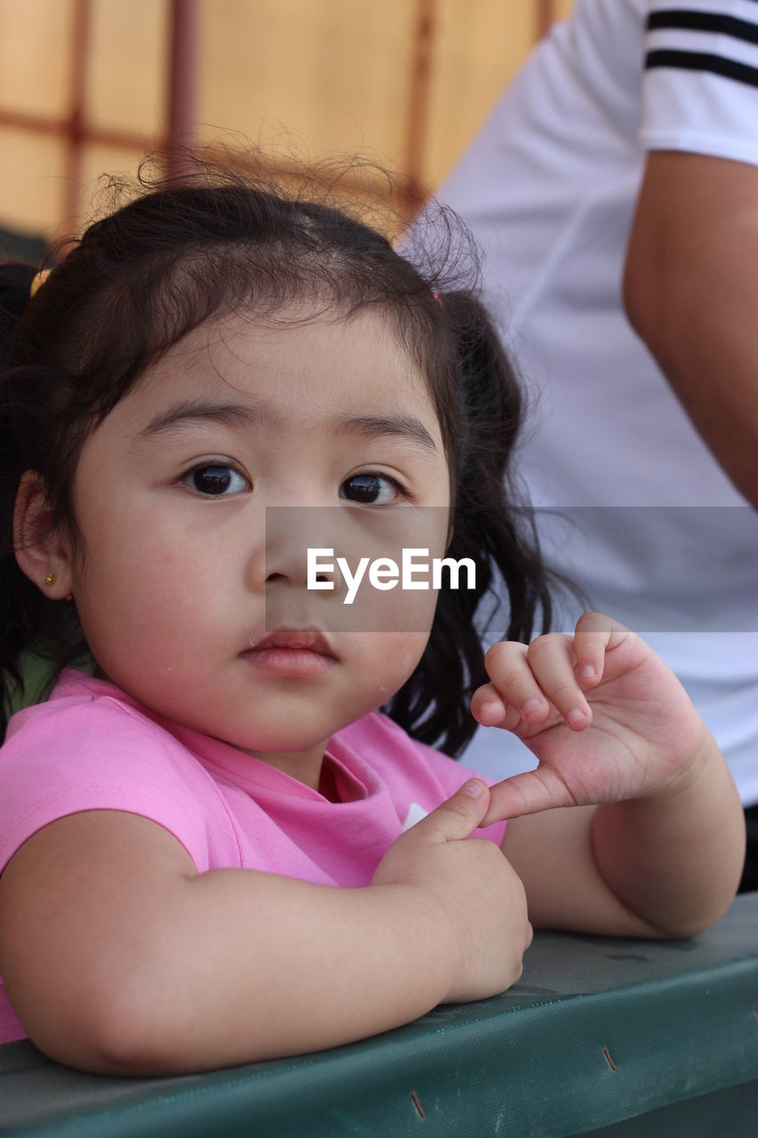 CLOSE-UP PORTRAIT OF A GIRL WITH HANDS